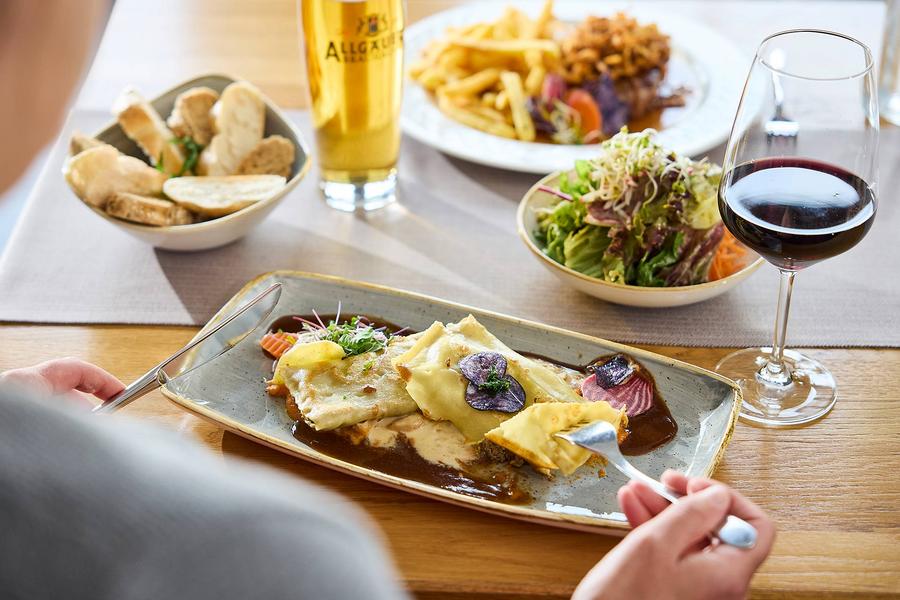 Eine Frau genießt hausgemachte Maultaschen mit frischem Salat