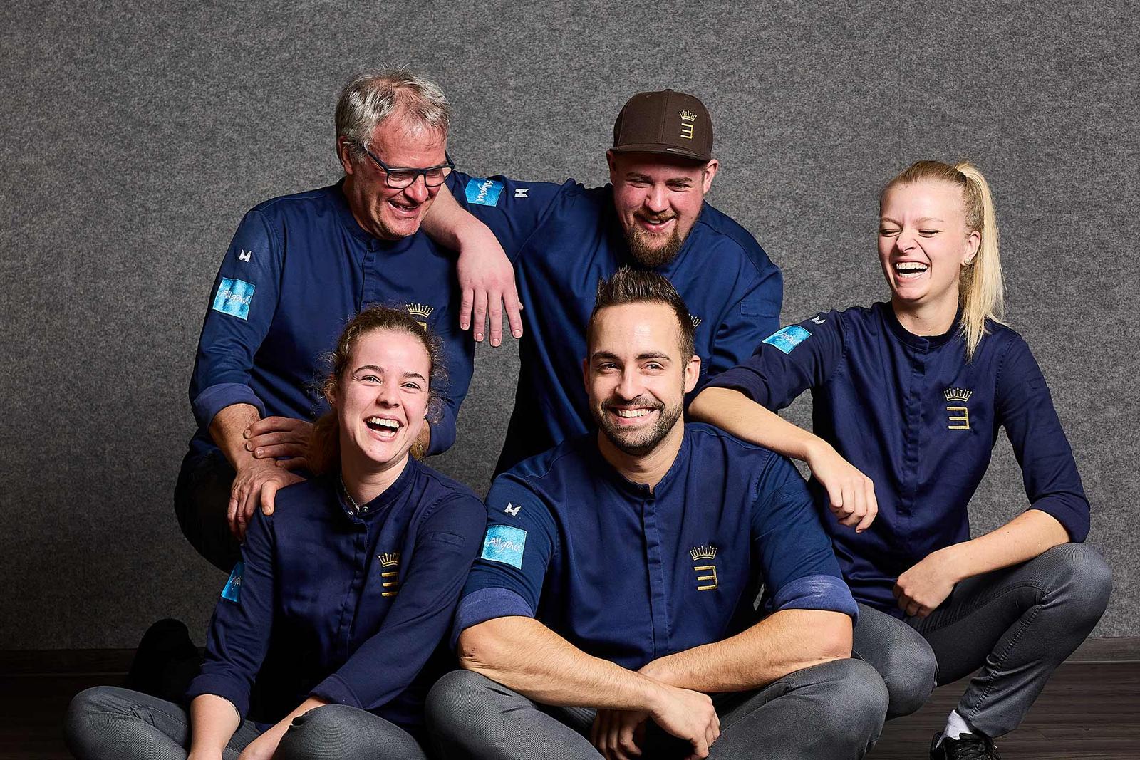 Eine Gruppe Köche lacht herzlich auf einem Gruppenfoto