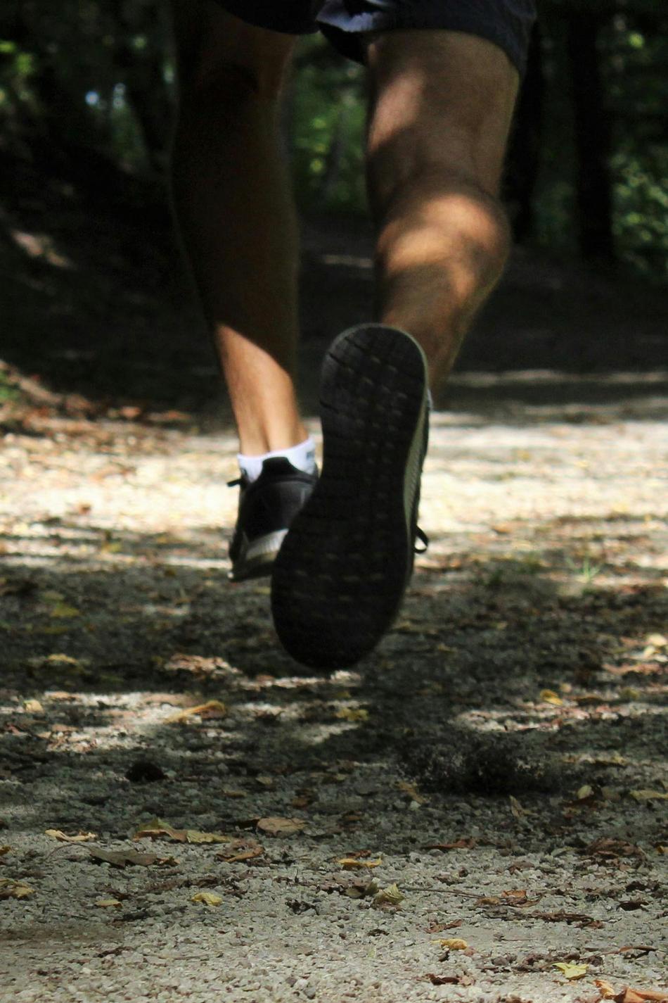 Detailaufnahme von Beinen beim Joggen im Wald