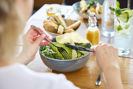 eine Frau genießt eine frische Salatbowl