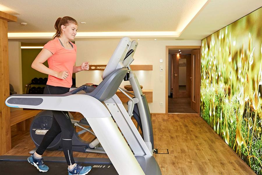 Fitnessraum im Hotel Krone in Immenstadt Stein. Eine Frau läuft auf einem Laufband