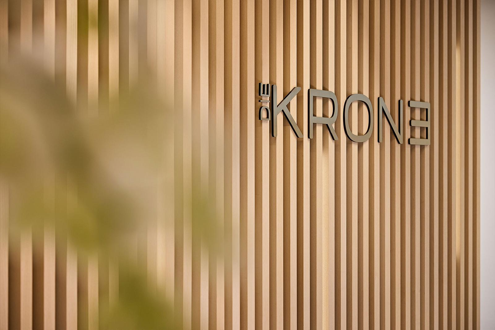 Detailaufnahme der Rezeption mit dem Logo des Hotels hinter dem Thresen