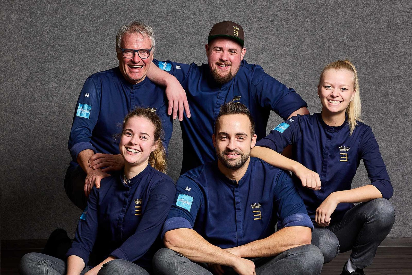 Eine Gruppe Köche lächelt herzlich in die Kamera