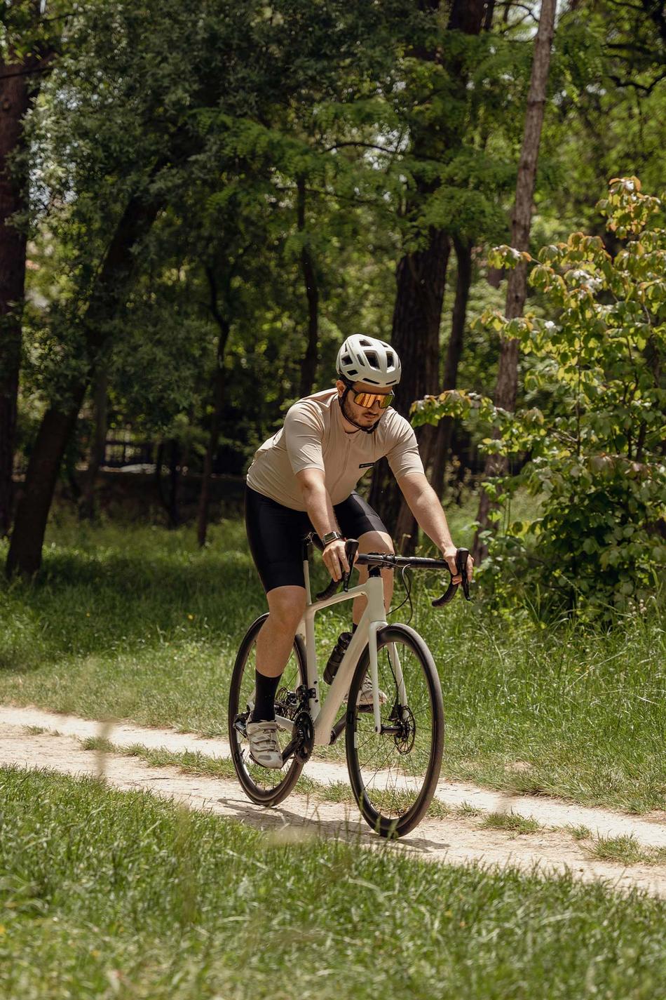 Ein Mann radelt auf einem Gravelbike durch den Wald