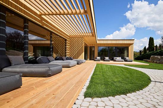 Blick in den Außenbereich des Spas mit Sonnenliegen und Gartenanlage