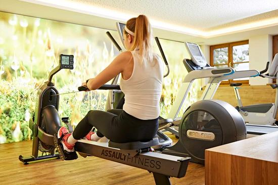 Eine junge Frau trainiert am Rudergerät im Fitnessraum des Hotel Krone