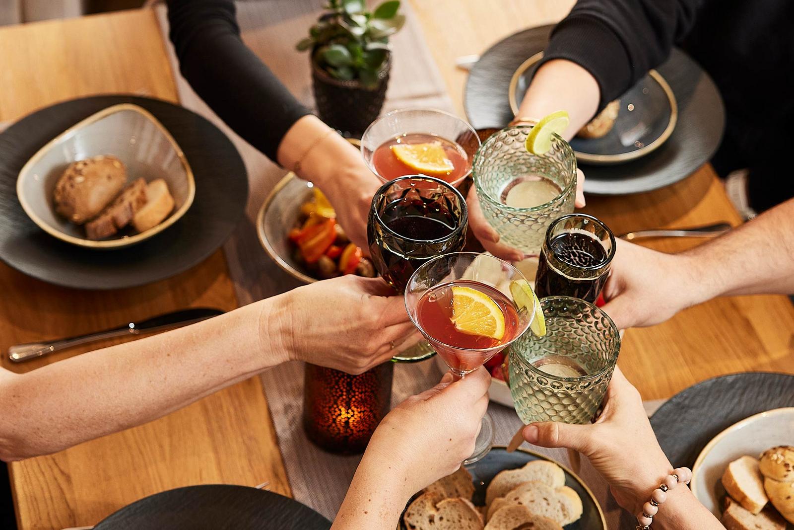 mehrere Personen stoßen mit verschiedenen Getränken an