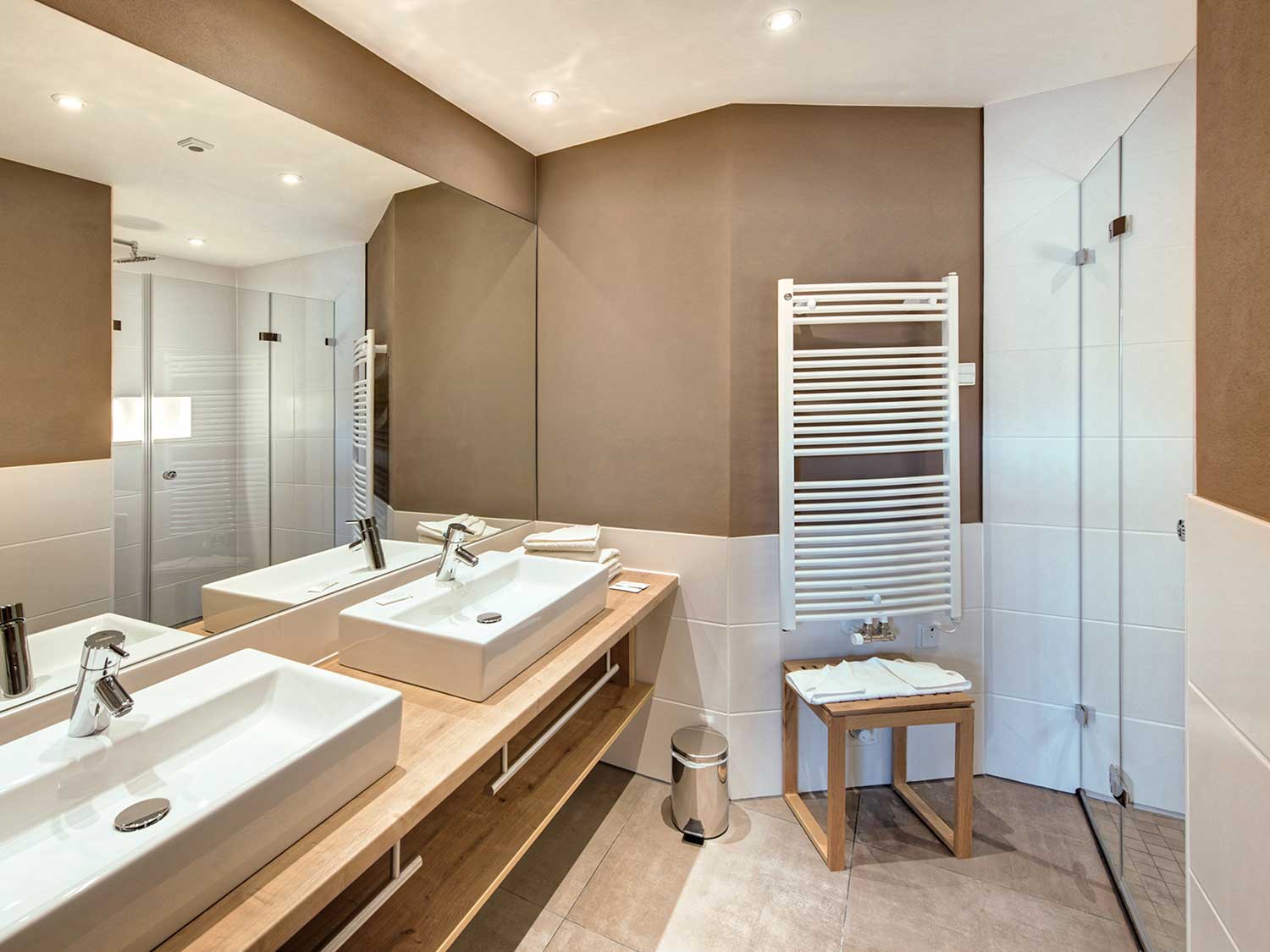 Badezimmer mit Doppelwaschbecken und Handtuchwärmer der Krone Suite. 