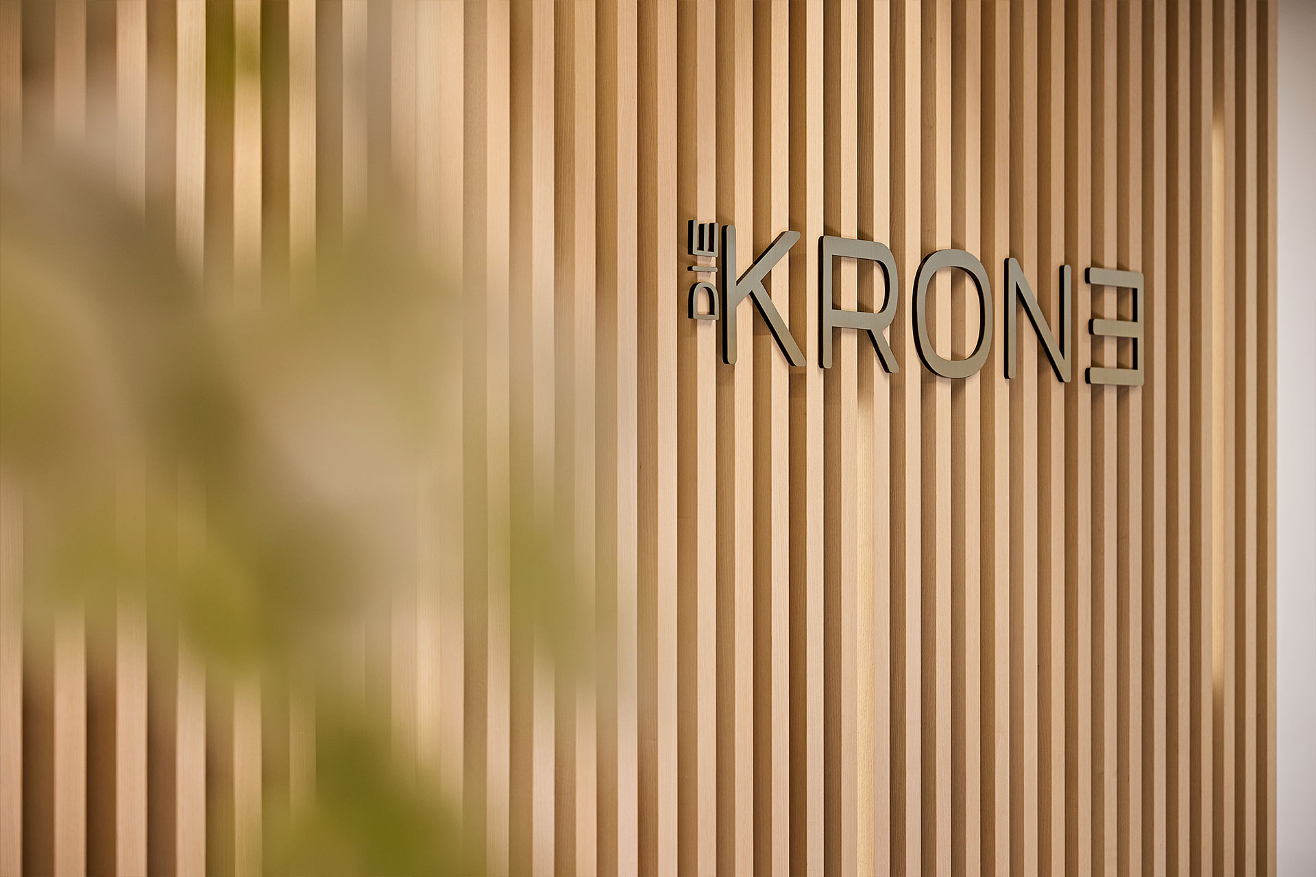 Detailaufnahme der Rezeption mit dem Logo des Hotels hinter dem Thresen