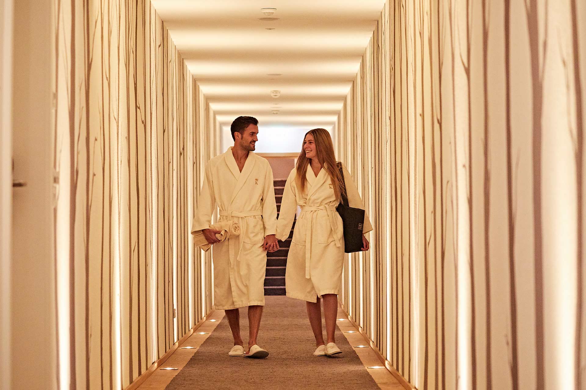 Ein Paar begibt sich durch einen Gang in den Spabereich des Hotels