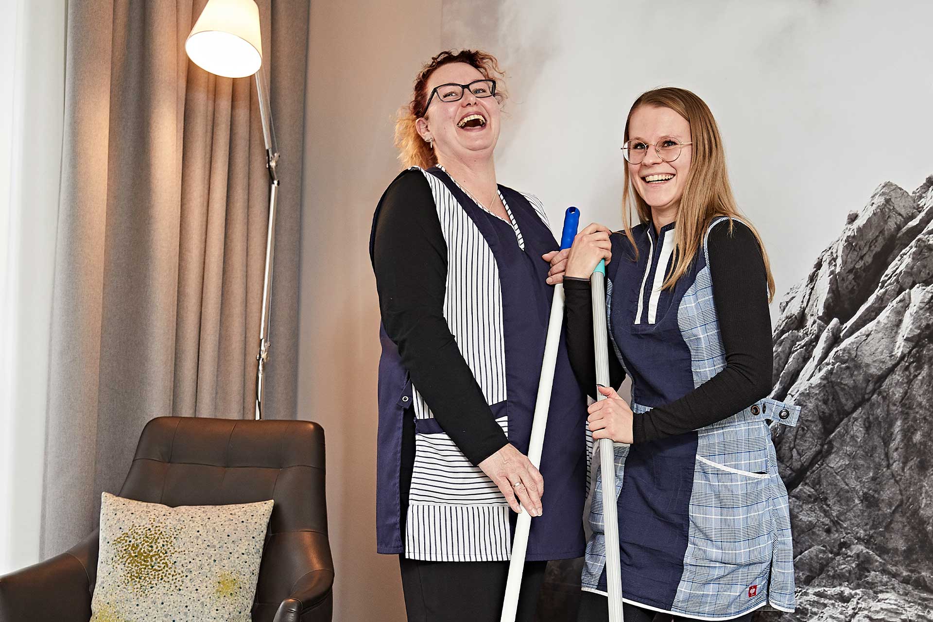 Zwei Damen aus dem Housekeeping lachen herzlich in die Kamera