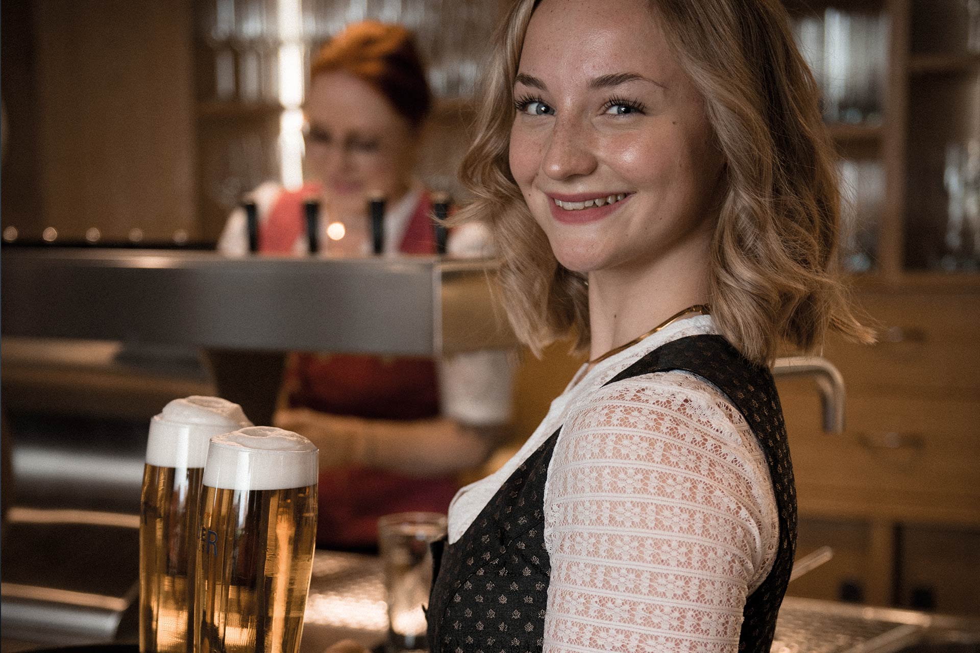 Eine junge Kellnerin lacht in die Kamera